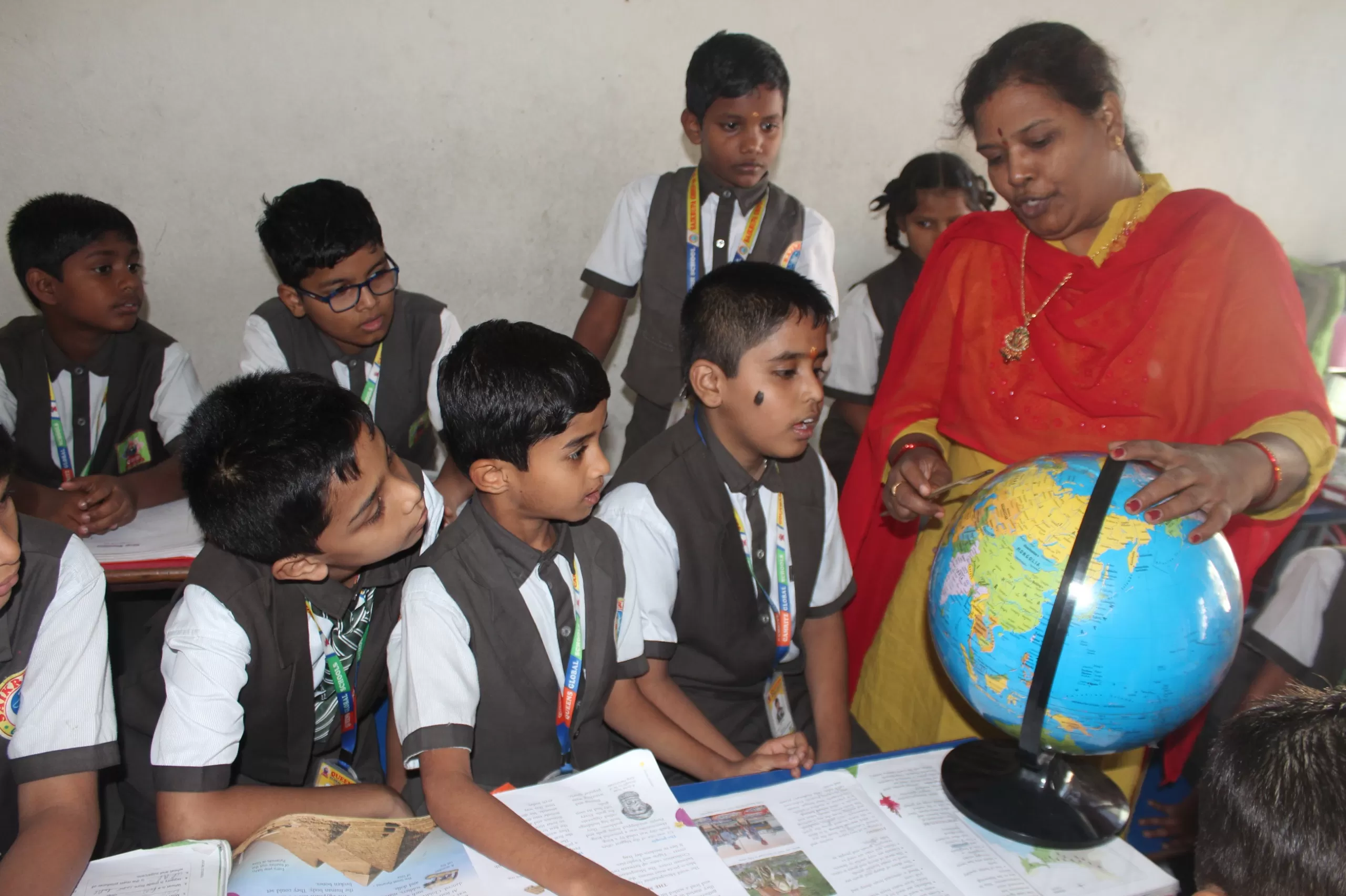 Students actively learning in an interactive classroom at Queens Global School, Kavadiguda, enhancing engagement and critical thinking.